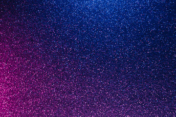 Neon glitter background. Grain texture. Defocused sparkles. Bokeh glow. Fluorescent blue magenta pink color gradient light shimmering sequin pattern.