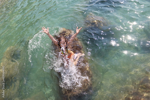 Girl in an orange swimsuit swims in the sea