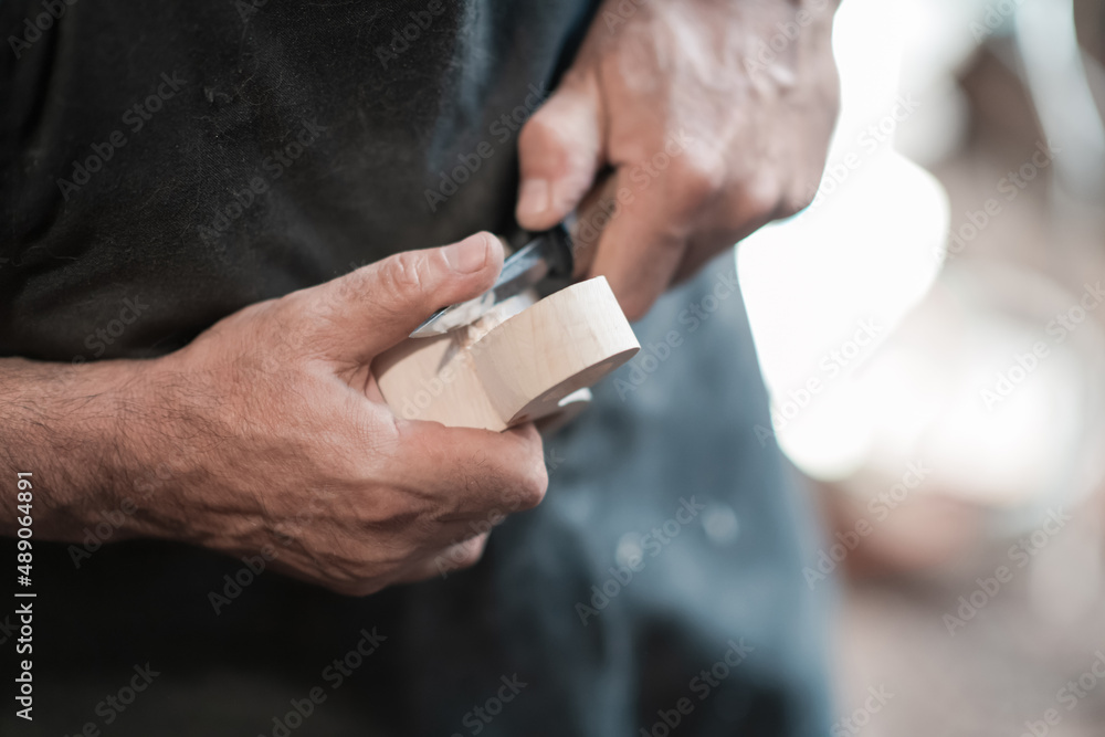 Hands carving cup from wood, working with chisel close up. Wooden workshop. Process of making wooden kitchenware Hands carving cup from wood, working with chisel close up. Wooden workshop. Process of making wooden kitchenware