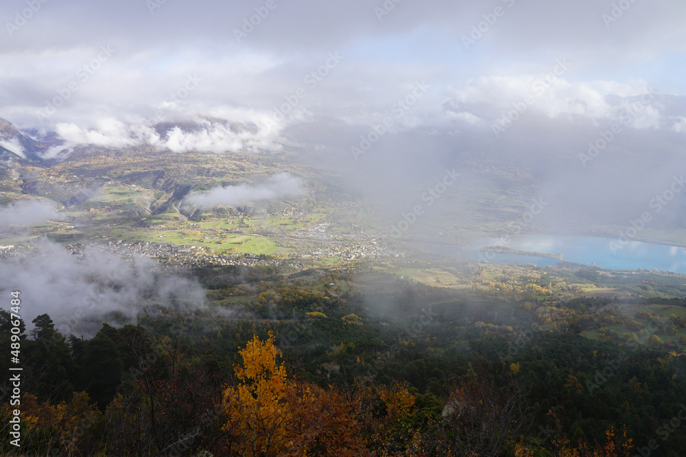 fog over the mountains and Serre Ponçon lake, alps, france on a fall day