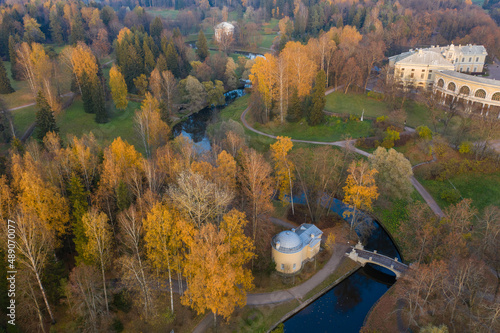 Panoramic aerial view of the Pavlovsk Park and the Pavlovsk Palace on an autumn evening.Bright autumn landscape,Slavyanka river,centaur bridge,Yellow leaves on top of trees.A suburb of St. Petersburg.