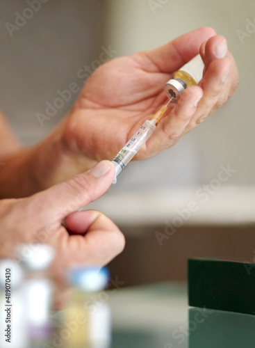 Getting the competitive edge. Closeup of a man filling a syringe with a clear liquid. © Julie F/peopleimages.com