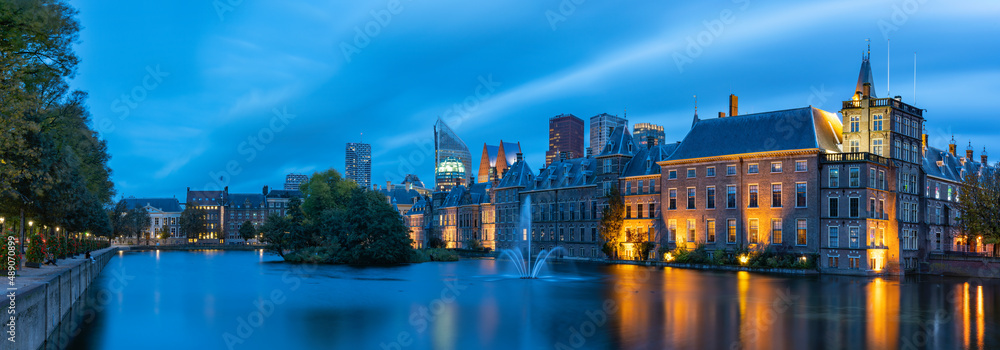 Panoramic photo during the blue hour on a windy autumn day of the Hofvijver and the Binnenhof with the parliament buildings in The Hague