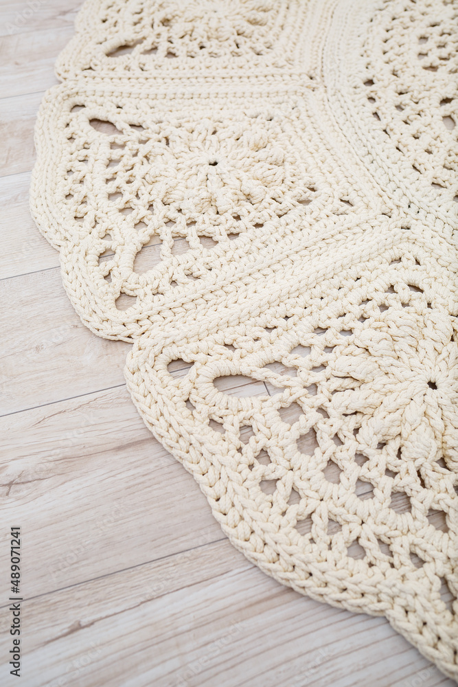 Handmade carpet knitted from natural threads, flooring, natural cotton. Beige handmade carpet. Knitted decorative item Handmade carpet knitted from natural threads, flooring, natural cotton. Beige handmade carpet. Knitted decorative item