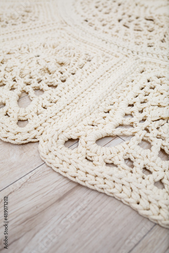 Handmade carpet knitted from natural threads, flooring, natural cotton. Beige handmade carpet. Knitted decorative item