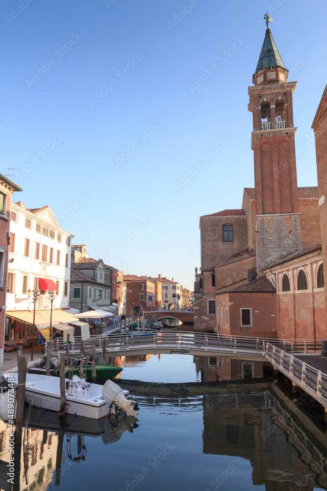 View of town Chioggia with canal Vena and church steeple of Chiesa della Santissima Trinita in Veneto, Italy