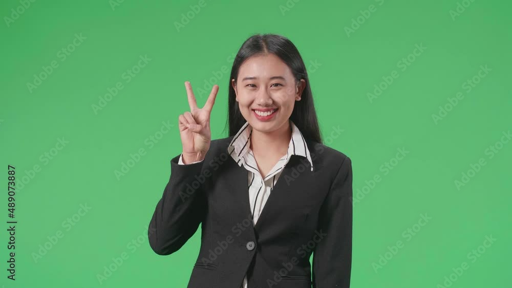 An Asian Business Woman Showing Gesture Peace And Smiling While Standing On Green Screen In The Studio
An Asian Business Woman Showing Gesture Peace And Smiling While Standing On Green Screen In The Studio
