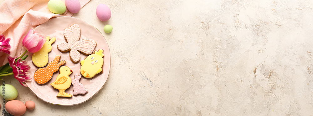 Plate with tasty Easter cookies on grunge background with space for text