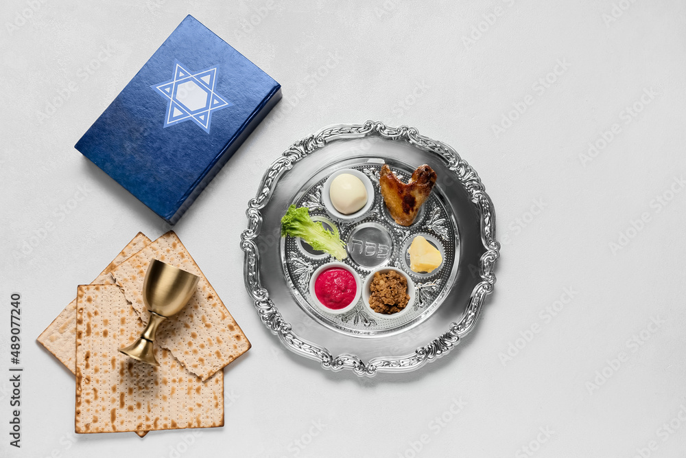 Composition with Passover Seder plate, matza and Torah on white background Composition with Passover Seder plate, matza and Torah on white background