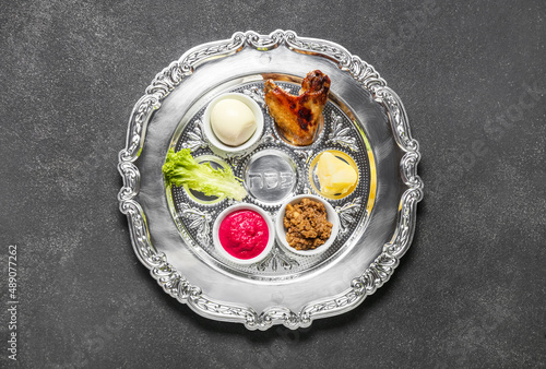 Passover Seder plate with traditional food on dark background photo