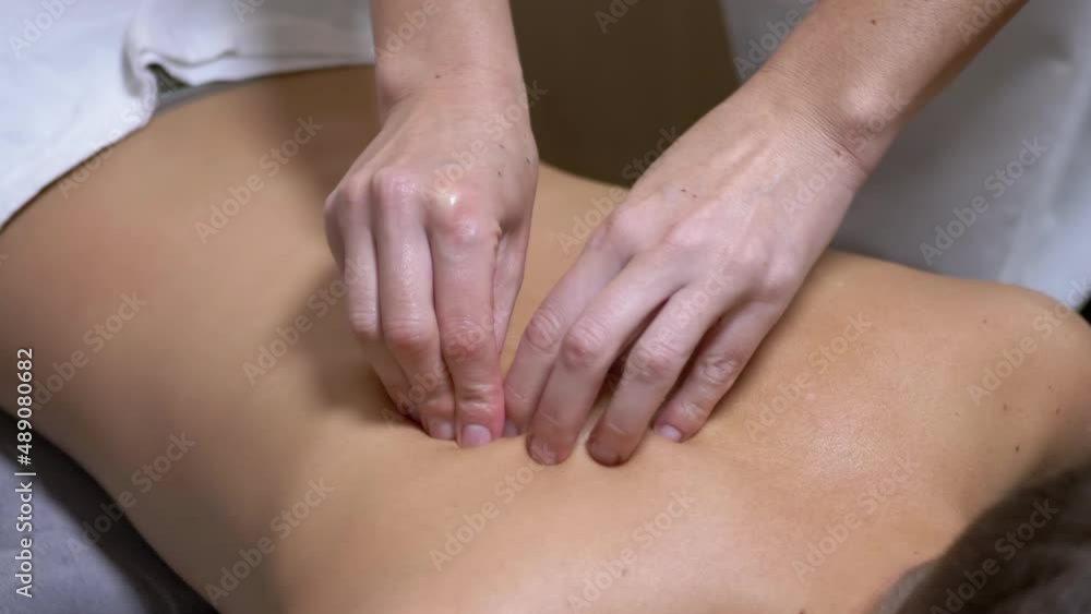 Hands of the Masseur are Massaging Back of a Teenager, a Child in a Spa Salon. Therapeutic, preventive massage session using oil. Eliminating pain, relaxing muscles, improving blood circulation. Zoom. Hands of the Masseur are Massaging Back of a Teenager, a Child in a Spa Salon. Therapeutic, preventive massage session using oil. Eliminating pain, relaxing muscles, improving blood circulation. Zoom.