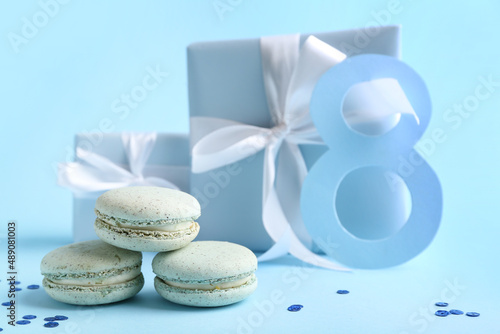 Delicious macaroons on color background. International Women s Day celebration