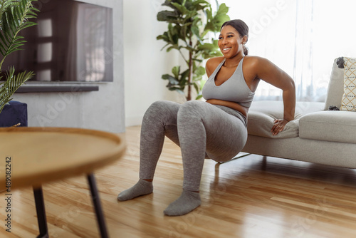 African american woman working out in home livingroom gym