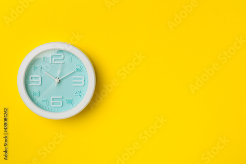 Blue clock on color background, top view