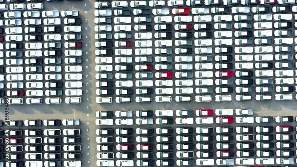 Aerial view from bottom to top New cars are produced from a car factory parked in a large number of parking lots to prepare for export abroad Aerial view from bottom to top New cars are produced from a car factory parked in a large number of parking lots to prepare for export abroad
