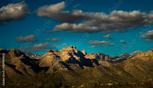 2022-02-23 THE SANTA CATALINA MOUNTAINS WITH A CACTUS FIELD AND DARK CLOUDS IN A BLUE SKY IN TUCSON ARIZONA photo