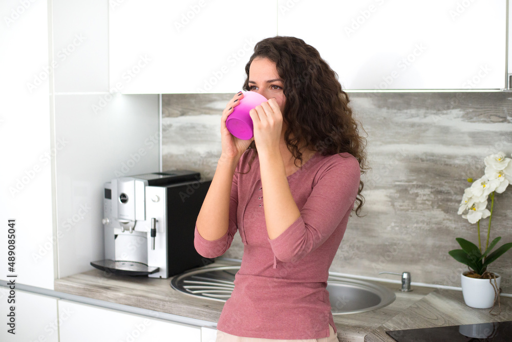 Beautiful young woman drinking morning coffee in the kitchen Beautiful young woman drinking morning coffee in the kitchen
