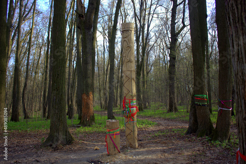 The temple of a pagan idol in the park. Statues made of wood, a temple in the forest