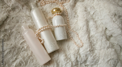 pearls and perfumes lie on the fur

