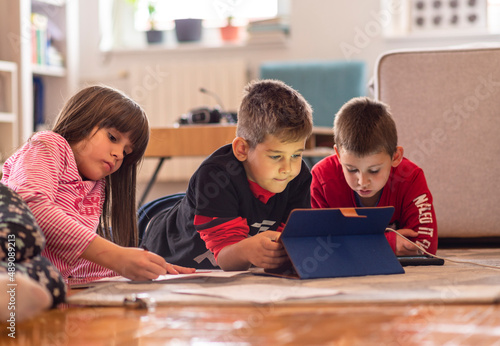 Kids playing with laptop computer at home 