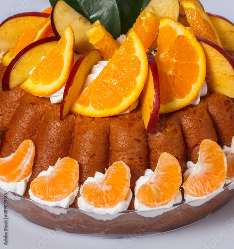 Dettaglio dolce napoletano babà al rum con frutta fresca e panna