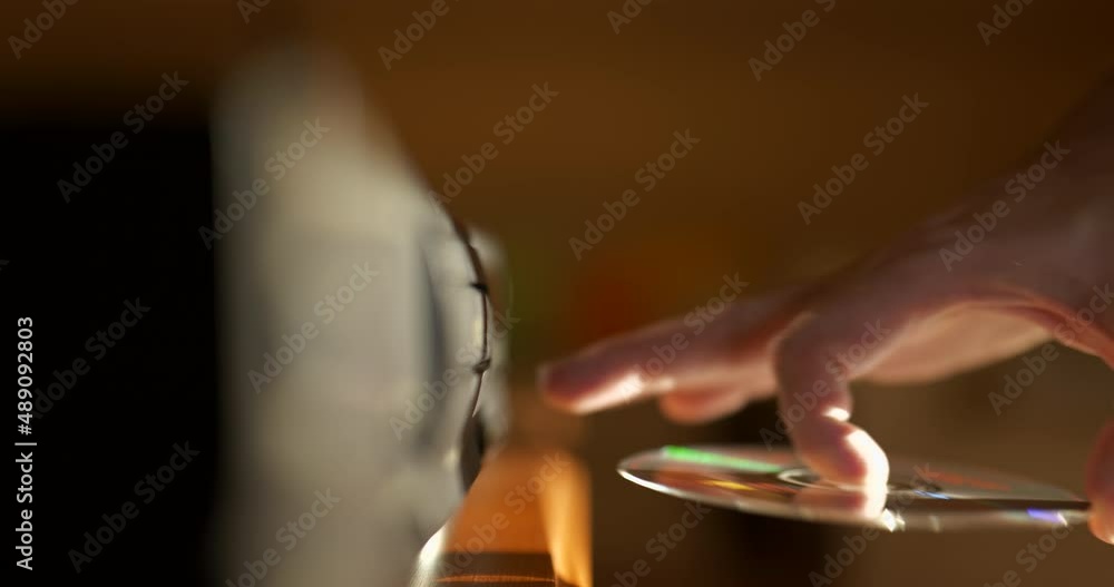 Man Loading CD Into a Compact Disc player