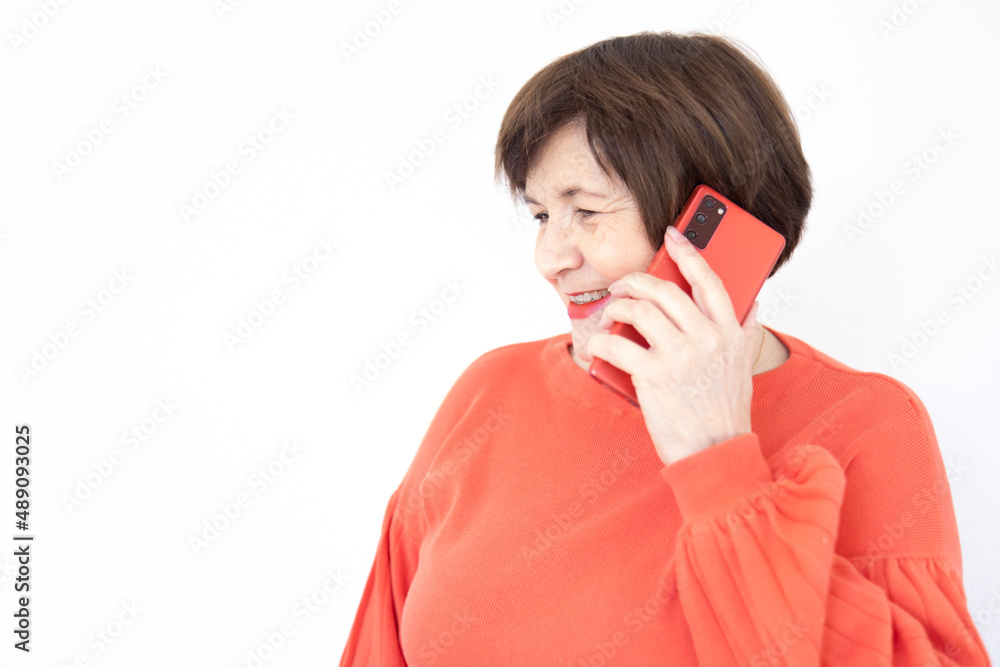 Old lady with short hair smiling and talking on cell phone with white background sidewayes photo Old lady with short hair smiling and talking on cell phone with white background sidewayes photo