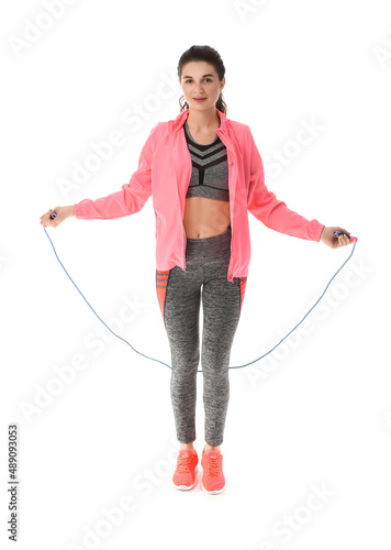 Young sporty woman skipping rope on white background