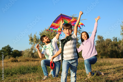 Cute little boy with kite and his parents in park