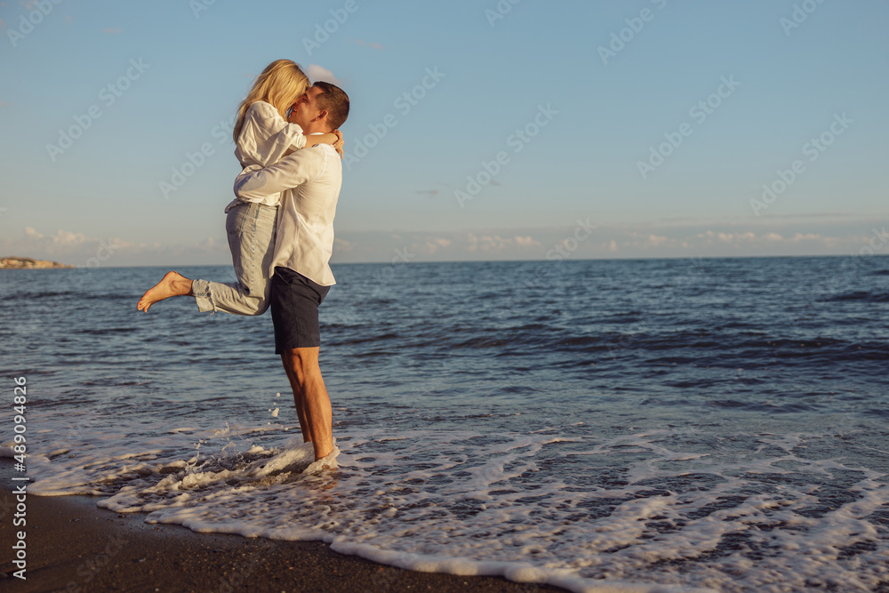 Full length photo man and woman standing on coast and kissing