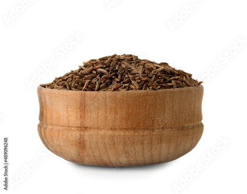 Wooden bowl of cumin seeds on white background
