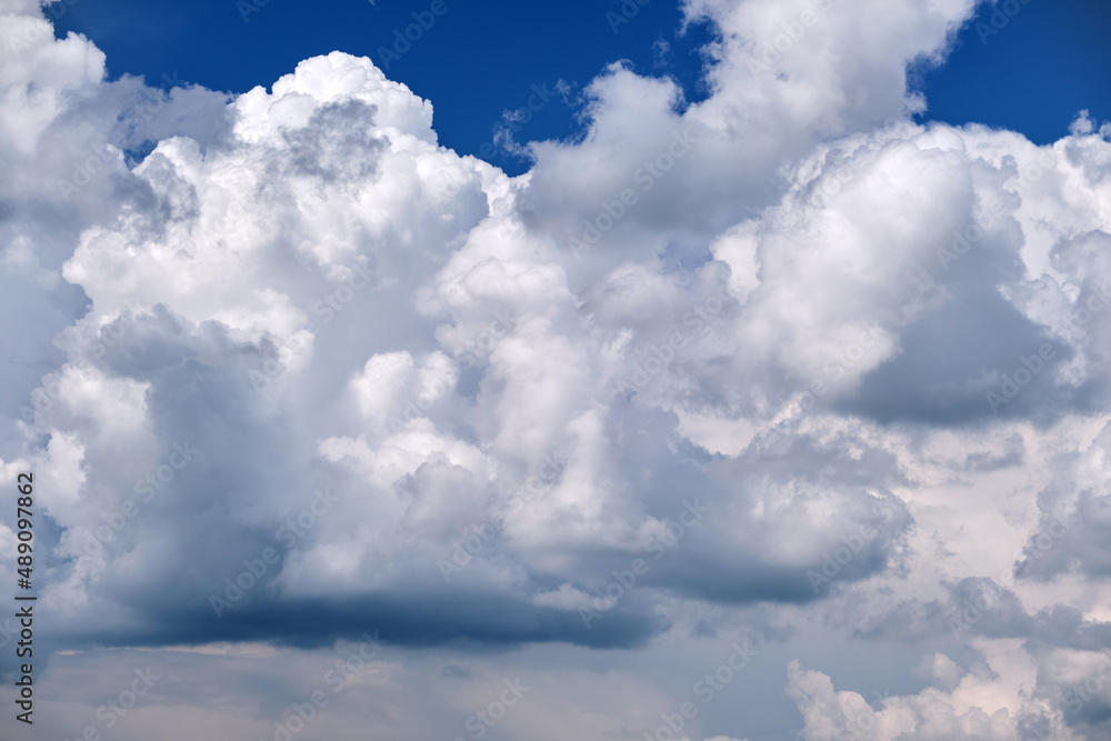 Bright landscape of white puffy cumulus clouds on blue clear sky Bright landscape of white puffy cumulus clouds on blue clear sky