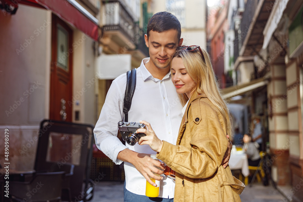 Charming couple looking at the camera standing on street Charming couple looking at the camera standing on street