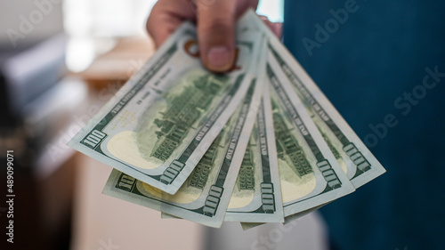 Man is holding a five hundred dollars