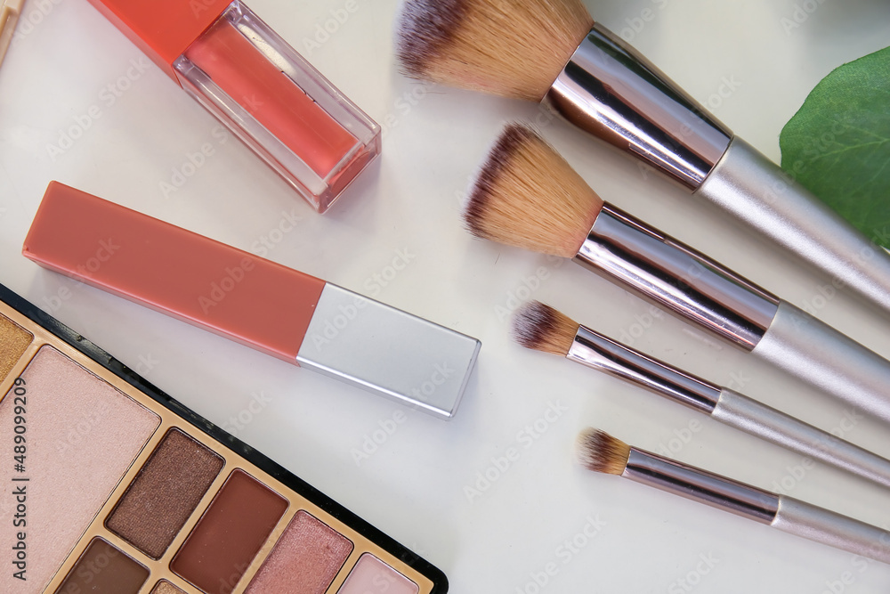 Decorative cosmetics with brushes on white table of makeup artist, closeup Decorative cosmetics with brushes on white table of makeup artist, closeup
