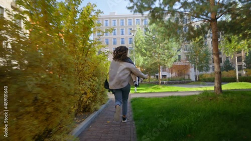 Handheld authentic and immersive shot of young woman run towards class or college inside university campus. Concept late for work or classes