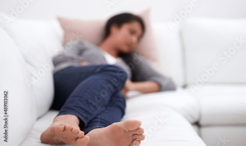 Taking a cat nap. A young woman taking a nap on her sofa.