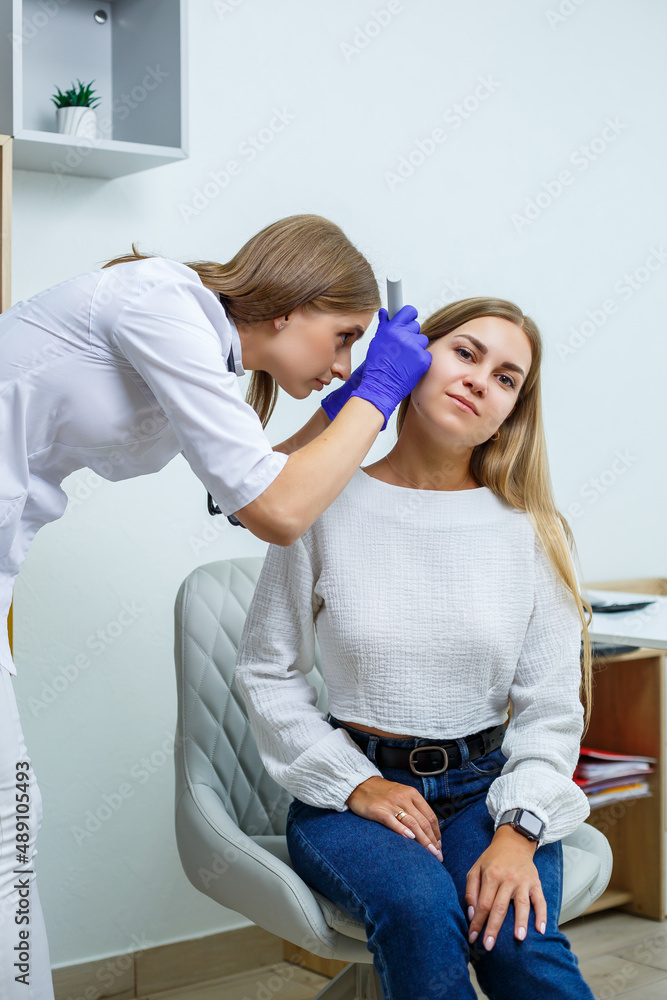 A young woman at the reception of a female doctor-specialist. Therapist conducts a preventive examination of a young woman in her office in a modern clinic A young woman at the reception of a female doctor-specialist. Therapist conducts a preventive examination of a young woman in her office in a modern clinic