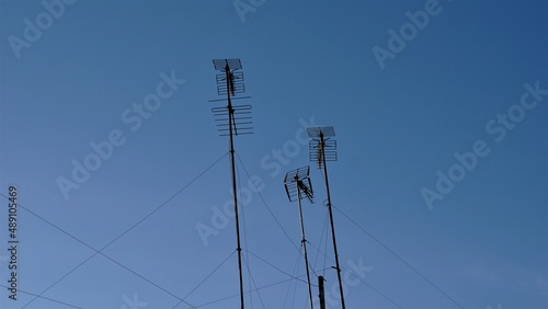 private television antennas against blue sky