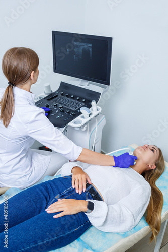 Woman patient reception at a female doctor in a medical center of a modern clinic, gives recommendations of a qualified specialist, health problems. Ultrasound examination of the thyroid gland