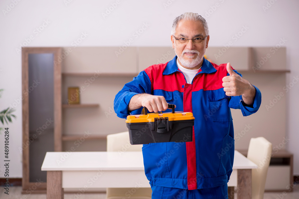 Old male carpenter working indoors Old male carpenter working indoors