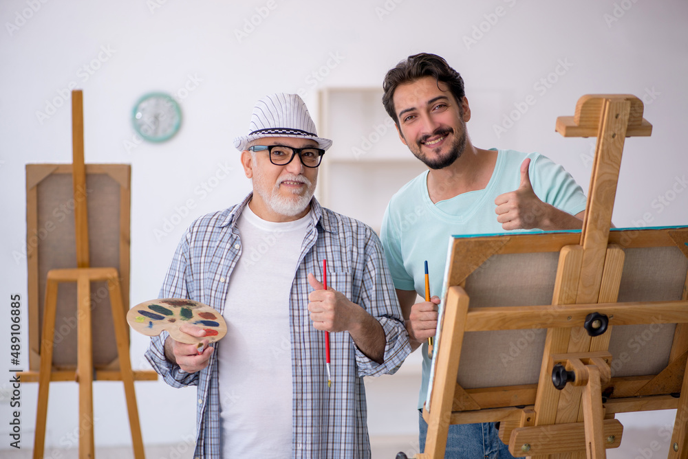 Old painter teaching young student at studio Old painter teaching young student at studio