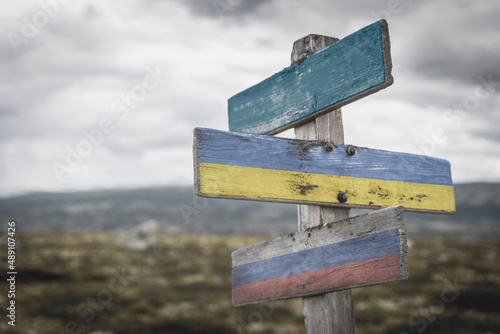 nato, ukraine and russia flag on signpost outdoors in nature.