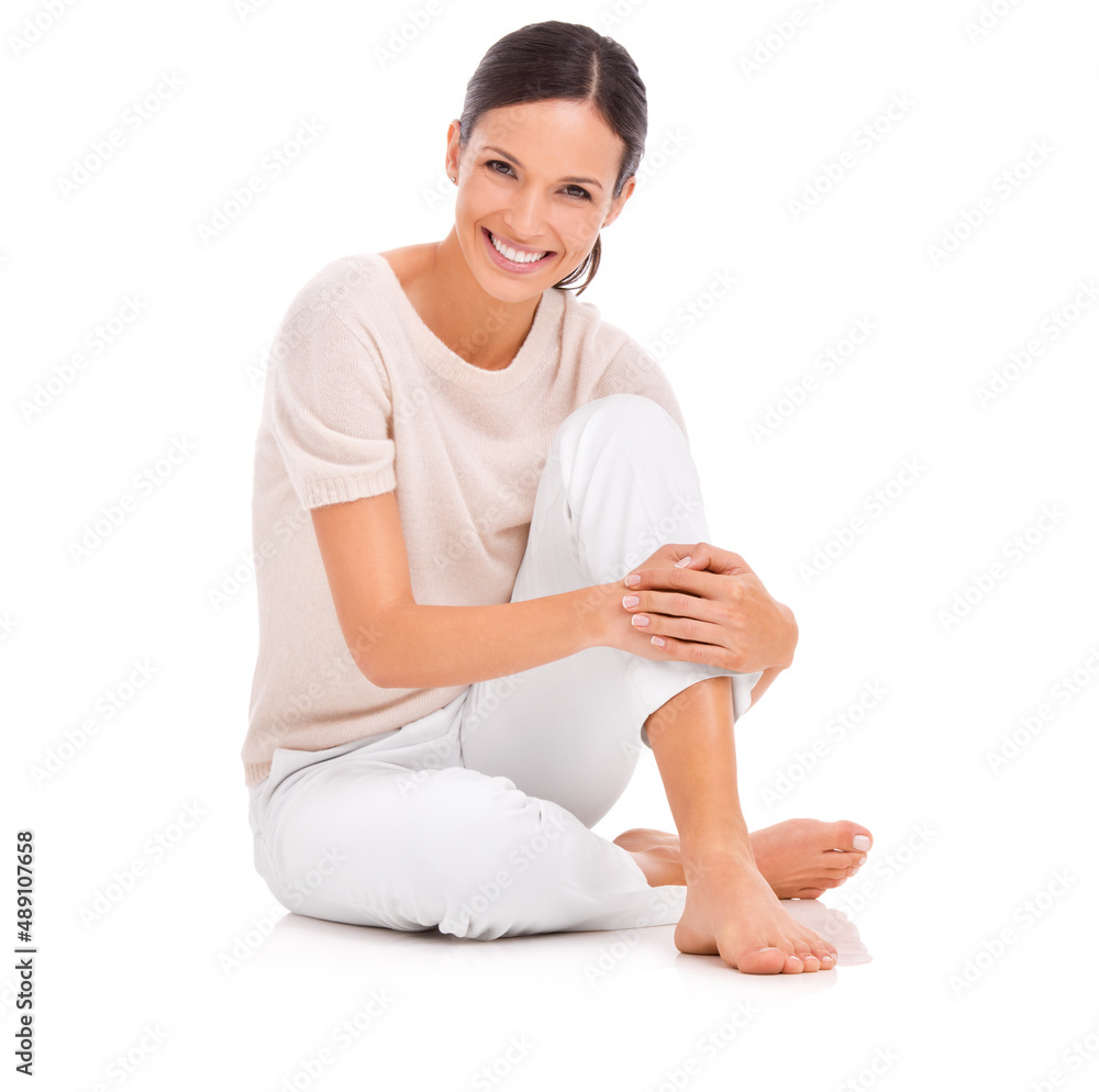 Shes everybodys woman. Studio shot of a young woman sitting on the floor and hugging her knee. Shes everybodys woman. Studio shot of a young woman sitting on the floor and hugging her knee.