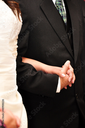 Couple holding hands while getting married