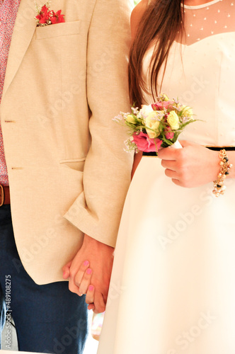 bride and groom holding hands with bouquet