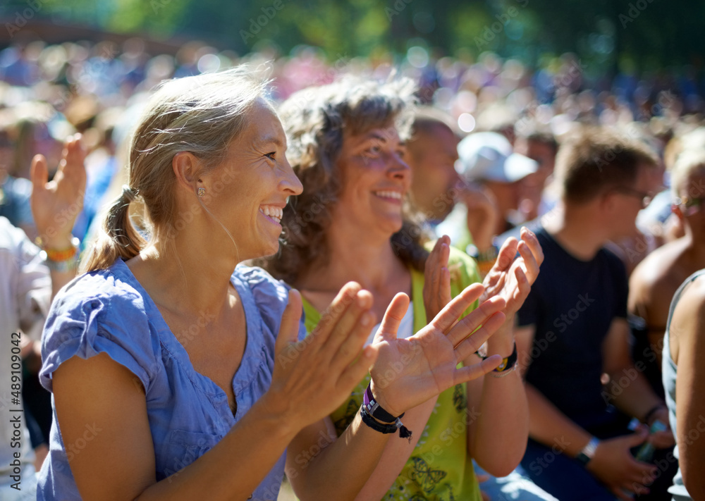 Foto de Enjoying the festival vibe. Two mature woman sitting outdoors at a  music festival. do Stock