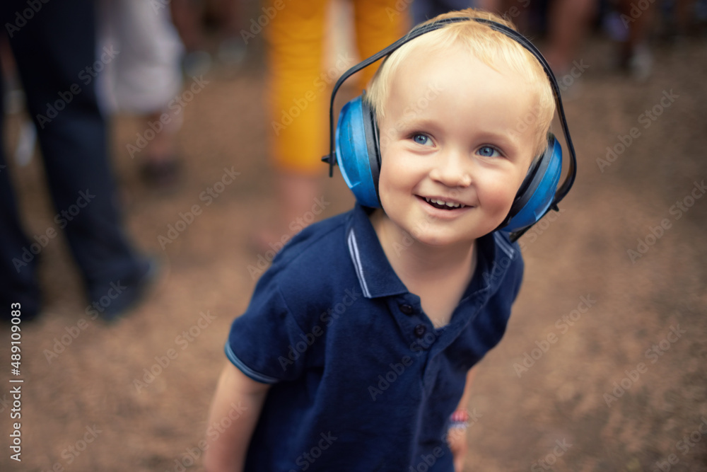 The best time of his young life. Closeup shot of a young boy wearing noise canceling headphones at an outdoor festival. The best time of his young life. Closeup shot of a young boy wearing noise canceling headphones at an outdoor festival.