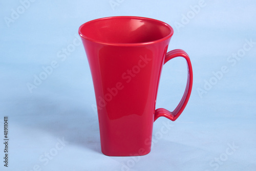 red color plastic cup with handle isolated on light blue background