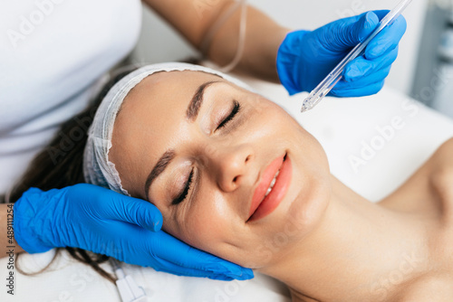 Beautiful middle-aged woman enjoys a skin rejuvenation treatment at a beauty salon.